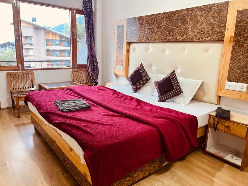 马拉里Hotel Solitaire - With Best View of Mountains的一间卧室配有一张带红色毯子的大床