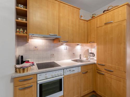 弗拉绍Apartment Dachstein-3 by Interhome的厨房配有木制橱柜、水槽和炉灶。