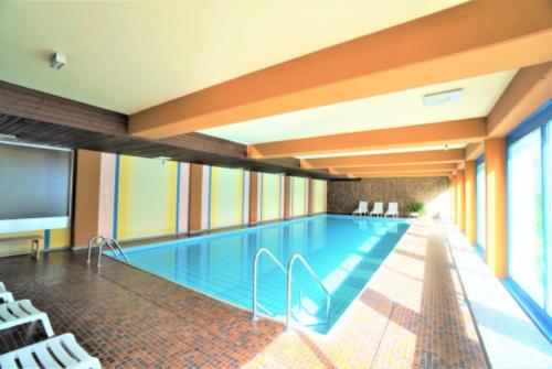 莱克斯Lovely 1-bedroom vacation studio apartment with pool and sauna的一座带电视的建筑内的游泳池