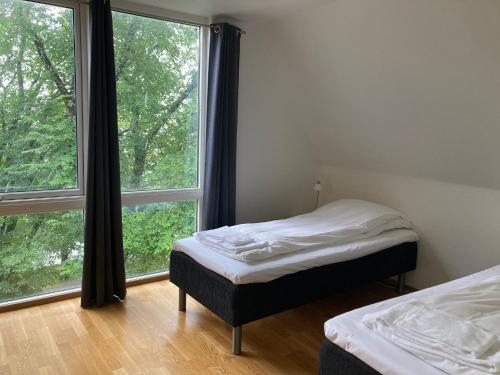 KopervikParken Terrasse Apartment Hotel的一间卧室设有两张床和大窗户