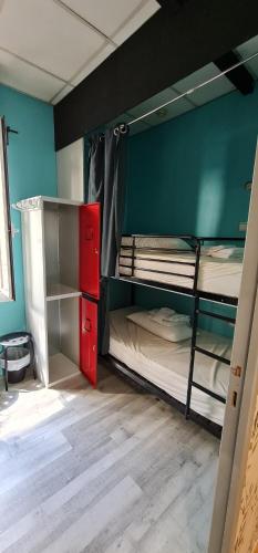 马德里GREEN Hostel MADRID GRAN VIA的客房设有两张双层床和红色橱柜。