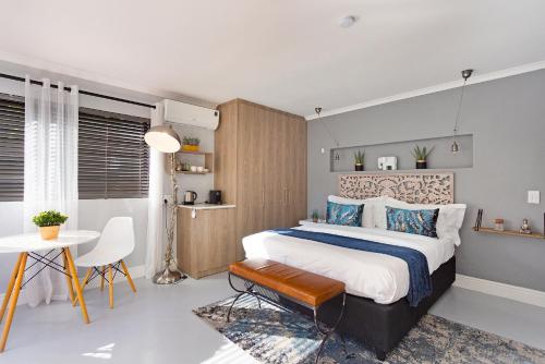布鲁堡史特兰Blouberg Studio Apartment的一间卧室配有一张大床和一张桌子