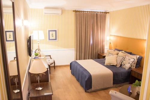 阿拉拉夸拉Hotel Dan Inn Araraquara的酒店客房配有一张床铺和一张桌子。