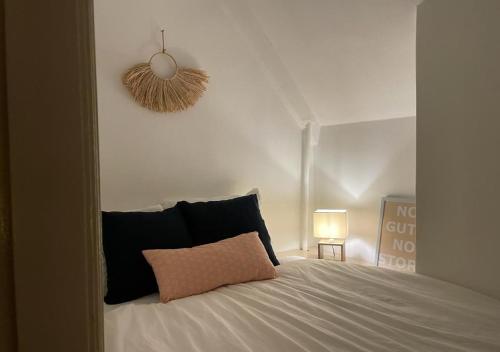 格罗宁根Characteristic ground floor apartment with box bed的卧室配有白色床和粉红色枕头