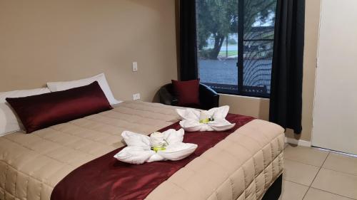 BoggabriBoggabri Motel的一间卧室配有一张白色鲜花的床