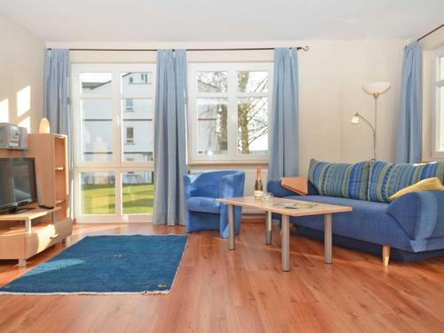 奥斯赛拜-塞林Villa Seerose - Appartement 01的客厅配有蓝色的沙发和桌子