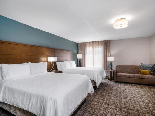 苏城Staybridge Suites - Sioux City Southeast, an IHG Hotel的酒店客房,设有两张床和一张沙发