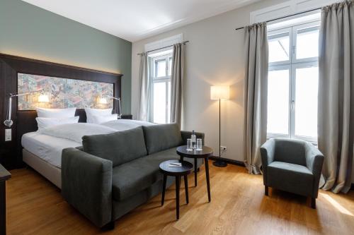 康斯坦茨Hotel Alte Post的一间卧室配有一张床、一张沙发和一把椅子