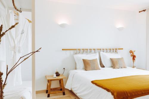 阿马兰特Oliveiras Village — Agroturismo的卧室配有白色床和黄色毯子