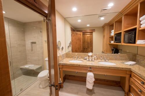 帕克城Hotel 2 Queen Hotel Room的一间带两个盥洗盆和淋浴的浴室