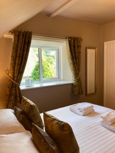 鲍内斯温德米尔奥克弗尔德别墅酒店的一间卧室设有一张大床和窗户