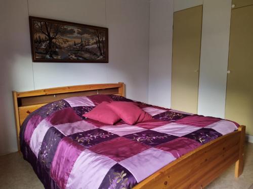 霍萨Holiday House Mäntyniemi的一间卧室配有一张带粉红色枕头的木床