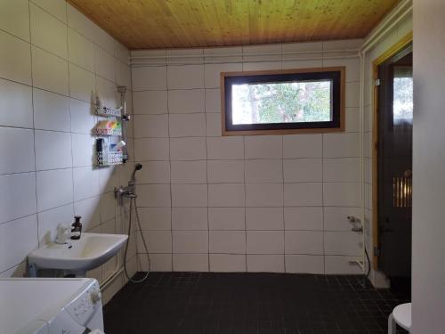 霍萨Holiday House Mäntyniemi的白色瓷砖浴室设有水槽和窗户