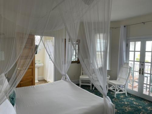 五月岬郡麦康伯酒店 的卧室配有一张床和一张桌子及椅子