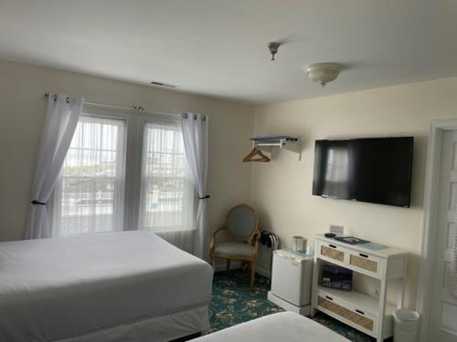五月岬郡麦康伯酒店 的一间卧室配有一张床和一台平面电视