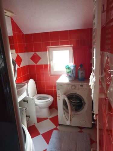 比耶洛波列Sve u jednom的红色和白色的浴室设有卫生间和洗衣机。