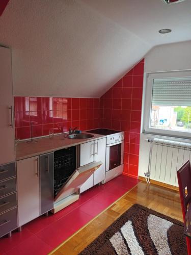 比耶洛波列Sve u jednom的红色的厨房设有水槽和柜台