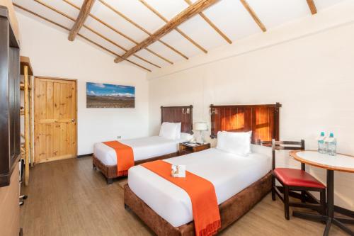 奇瓦伊科卡标准卡萨安迪娜酒店的酒店客房设有两张床和一张桌子。