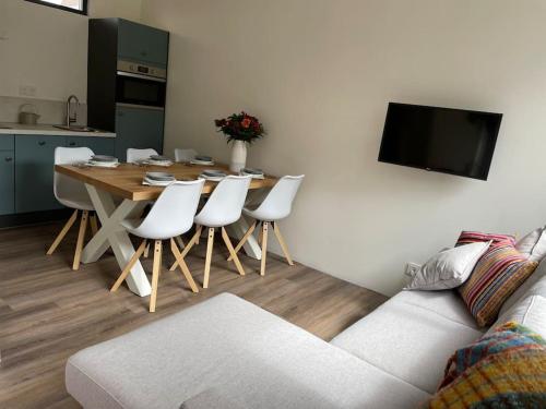 滨海韦克Het Zonnetje的客厅配有桌子和白色椅子