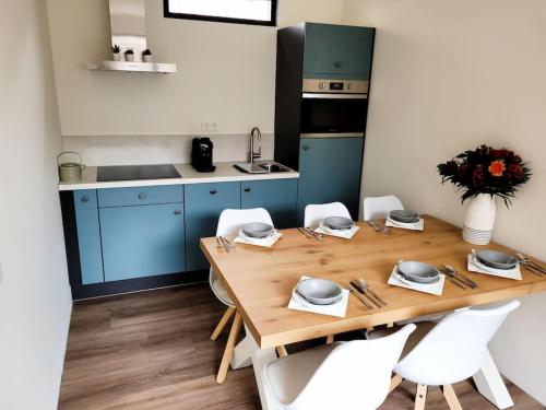 滨海韦克Het Zonnetje的厨房配有木桌和白色椅子