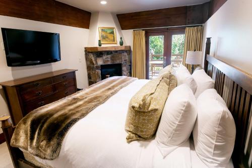 帕克城Deluxe King Room with Fireplace Hotel Room的一间卧室配有一张带白色枕头的床和电视。