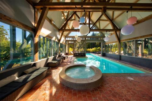 利翁拉福雷大赛尔夫和Spa酒店的一座室内游泳池,其建筑为大型建筑