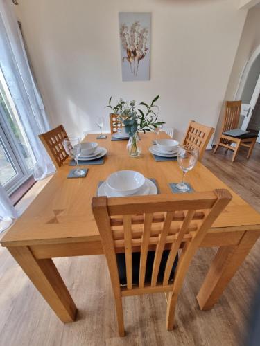 南本弗利特Contractors Home from Home的一张木桌,配有椅子和盘子及玻璃杯