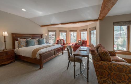 帕克城Deluxe King Hotel Room的卧室配有一张床和一张桌子及椅子