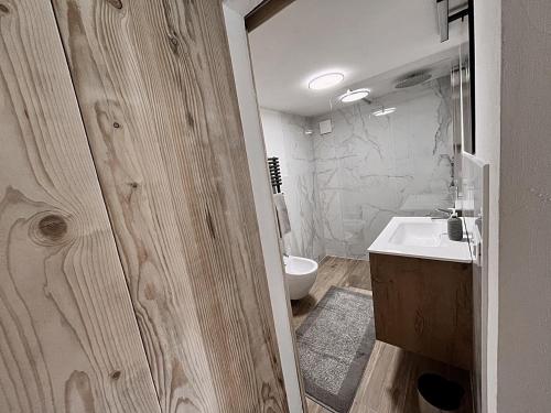 拉瓦罗内Loft Malga Laghetto的浴室配有白色水槽和卫生间。