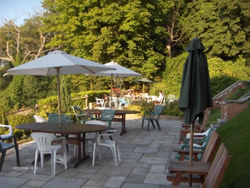 考斯罗斯赛别墅酒店的一个带桌椅和遮阳伞的庭院