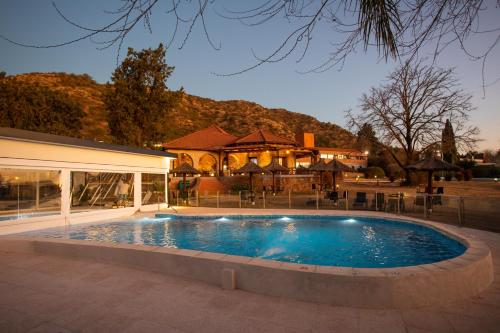 维拉卡洛斯帕兹Pinares del Cerro Resort & Suites的房屋前的大型游泳池