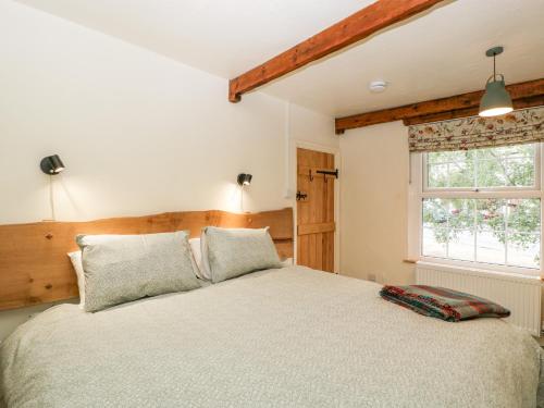 LydbrookTinmans Cottage的一间卧室设有一张床和一个窗口