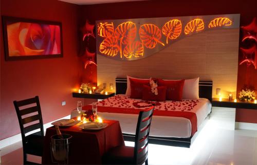 El AlcanforAuto Hotel Deluxe的卧室配有一张床和一张桌子及椅子