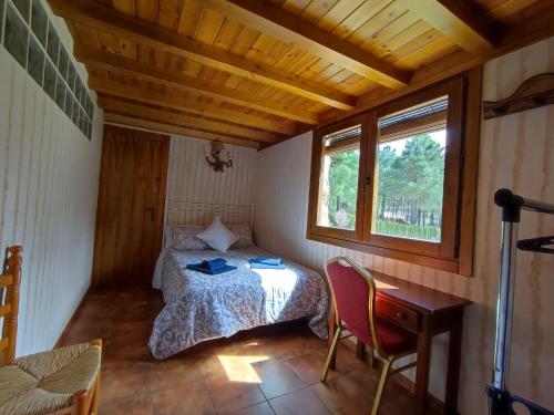 里奥帕尔Casa Esmeralda en ZAFIRO LAGUNAZO Parque Natural Rio Mundo Riopar的一间卧室配有一张床、一张书桌和一个窗户。