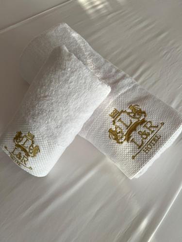 圣金Hotel LEON - Beach Front的床上的白色餐巾,上面有金色绣花