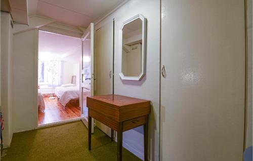 格雷伯斯塔德4 Bedroom Lovely Home In Grebbestad的客房设有木桌和镜子。