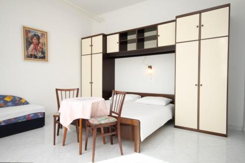木洛希尼Apartment Mali Losinj 7991b的一间卧室配有一张双层床和一张桌子及椅子。