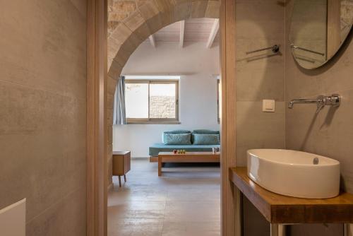 法拉萨纳Alma Natura Villas Falasarna- Avgerinos Villa的一间带水槽的浴室和一间带沙发的房间