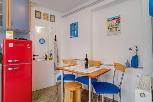 大洛希尼Apartments by the sea Veli Losinj, Losinj - 7959的厨房配有红色冰箱、桌子和椅子