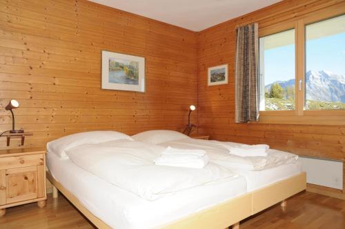 利德阿尔卑斯Favorite Parterre的卧室配有白色的床和窗户。