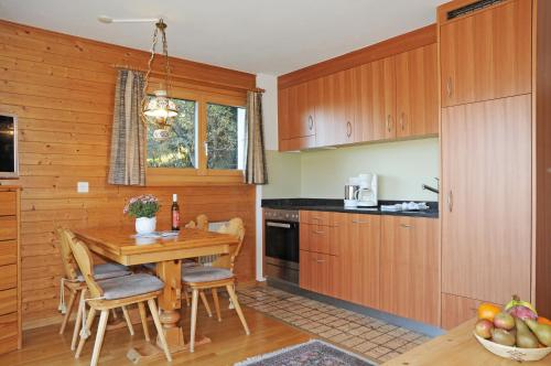 利德阿尔卑斯Favorite Parterre的厨房配有木制橱柜和木桌。