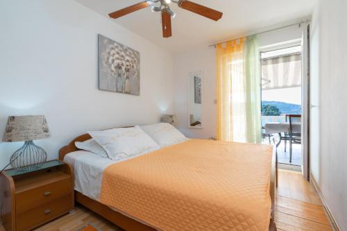 尼亚卢卡Apartments by the sea Cove Gradina, Korcula - 9273的一间卧室配有一张床,窗户配有桌子