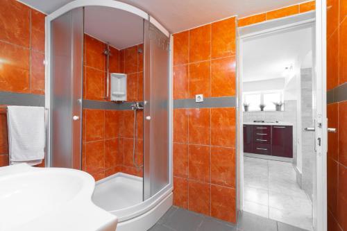 尼亚卢卡Seaside house for families with children Cove Stratincica, Korcula - 9265的浴室拥有橙色瓷砖墙壁和淋浴。