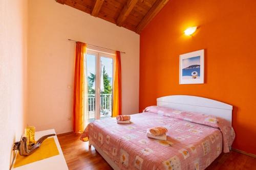 拉茨斯切Apartments by the sea Kneza, Korcula - 9168的一间卧室配有一张带橙色墙壁和窗户的床