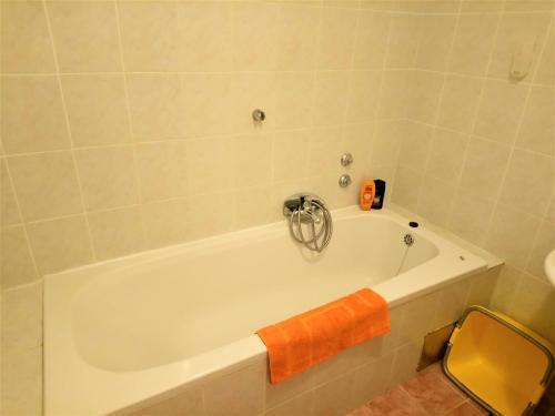 伊齐齐Apartments with a parking space Icici, Opatija - 7860的白色浴缸,上面有橙色毛巾