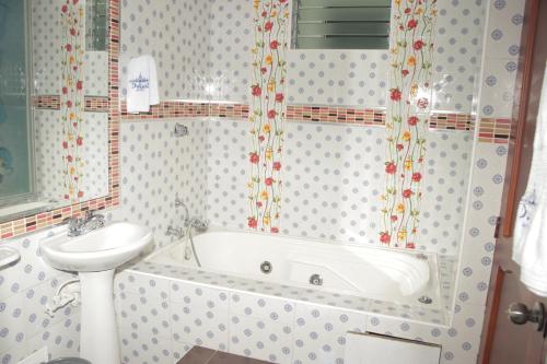 马尼萨莱斯Hotel Dubai的带浴缸和盥洗盆的浴室