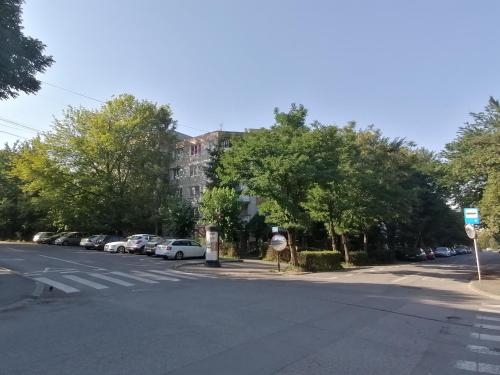 奥多尔黑塞库耶斯克Bethlen Apartman的一条空的街道,有一座建筑和汽车停放