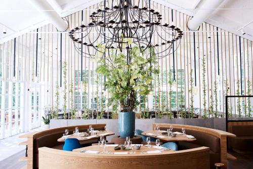 宰斯特科尔克博什城堡酒店的一间带桌子和大吊灯的用餐室