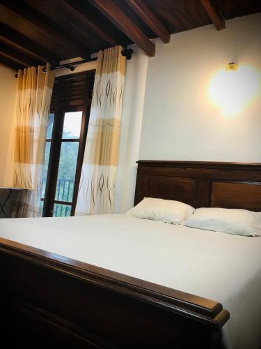 班德勒韦勒Mirador Cottage的一间卧室设有一张大床和窗户
