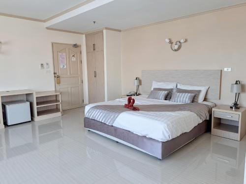 华欣瑟普莱城市酒店的一间卧室配有一张大床,上面有红泰迪熊